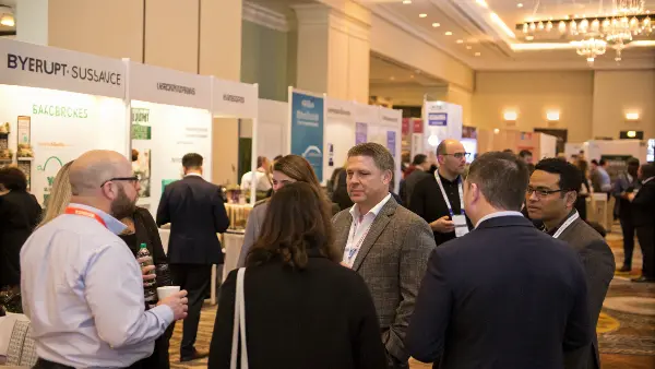two professionals talking and networking at a trade show event