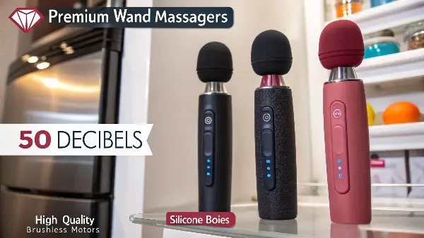 A collection of sleek, modern wand massagers arranged on a soft, neutral-colored background.