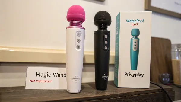 Waterproof Wand Massager in Use a person holding a modern, waterproof wand massager under a gentle stream of water