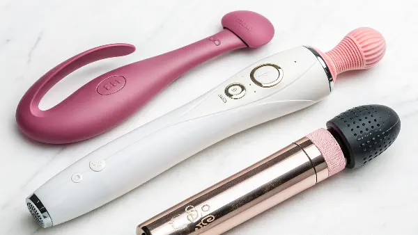 a flat lay of different types of silent massagers, including a wand, a G-spot toy, and an air pulse toy